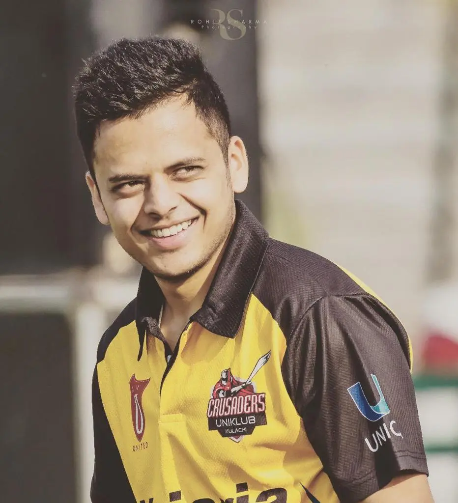 Arjun Gupta cricketer smiling in yellow and black Crusaders Uniklub Kulachi cricket jersey