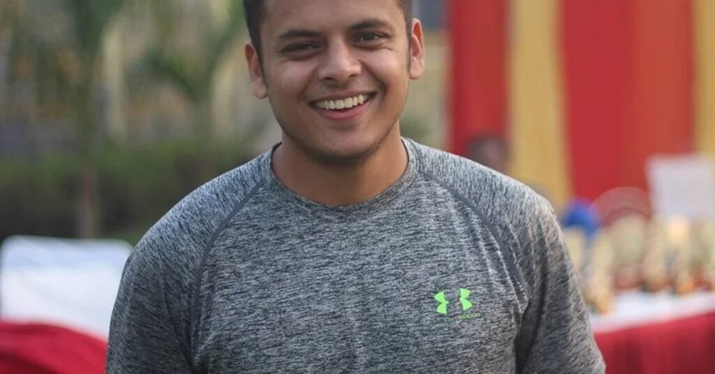 Arjun Gupta, Kragbuzz founder and Delhi cricketer, smiling at a sports event in athletic wear